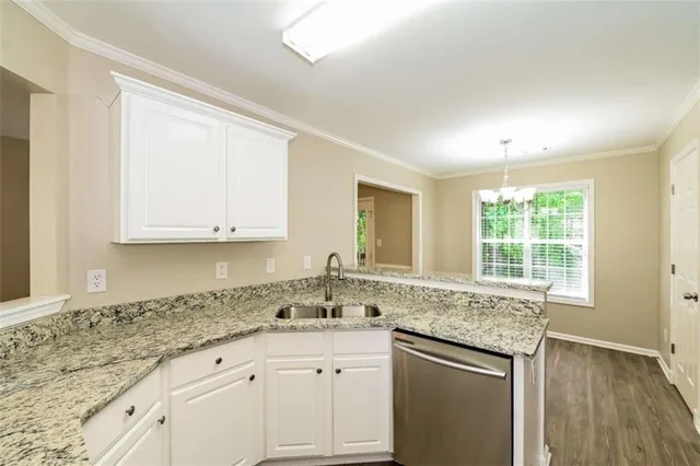 a kitchen with granite countertop white cabinets and a window