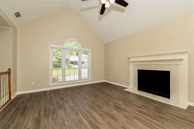 wooden floor fireplace and windows in an empty room