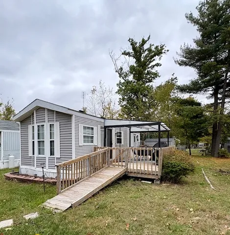 a view of a house with a deck and a yard