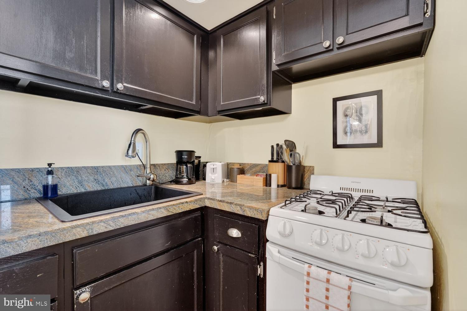 11 2nd Street Northeast, Unit 208 Washington, DC 20002 - Photo 8 of 12 a kitchen with stainless steel appliances granite countertop a sink stove and cabinets