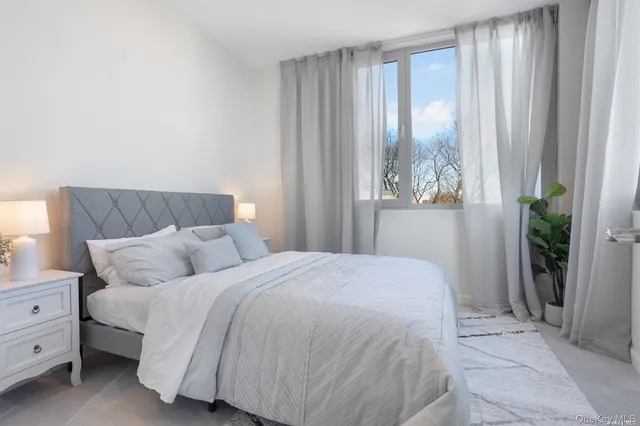 a bedroom with a bed and large window