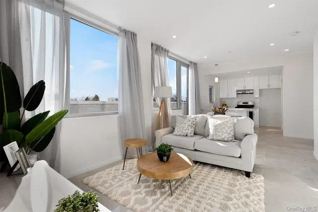 a living room with furniture a large window and a flat screen tv