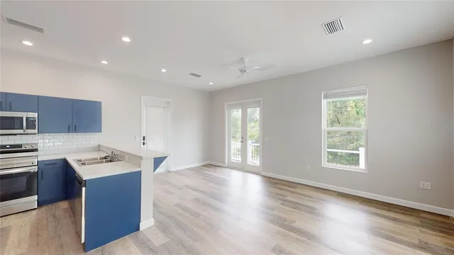 a kitchen with stainless steel appliances granite countertop a sink dishwasher a stove and a refrigerator