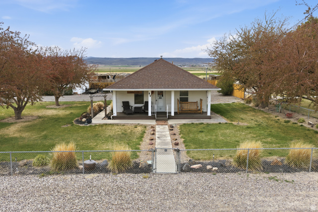 82 South 100 West Lyman, UT 84749 - Photo 26 of 27 View of front of home featuring a gate, a porch, a fenced front yard, and a shingled roof