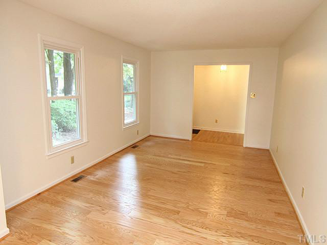 5521 Mapleridge Road Raleigh, NC 27609 - Photo 5 of 24 an empty room with wooden floor and windows