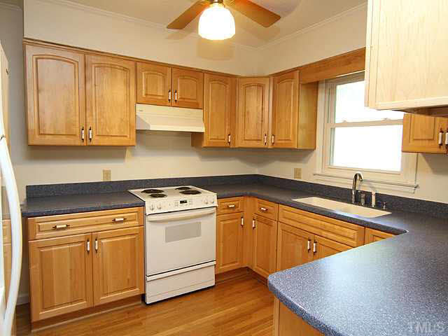 5521 Mapleridge Road Raleigh, NC 27609 - Photo 9 of 24 a kitchen with granite countertop wooden cabinets stainless steel appliances and a window