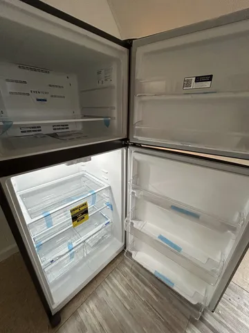 a view of empty room with wooden floor and electronic appliances