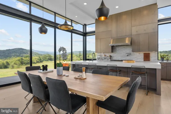 a kitchen with stainless steel appliances kitchen island granite countertop a sink table and chairs