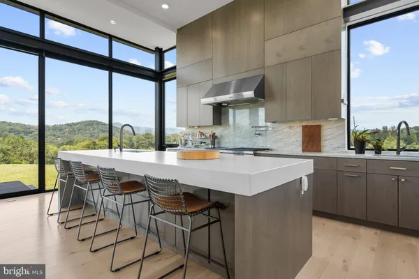 a dining room with stainless steel appliances granite countertop a sink and table chairs