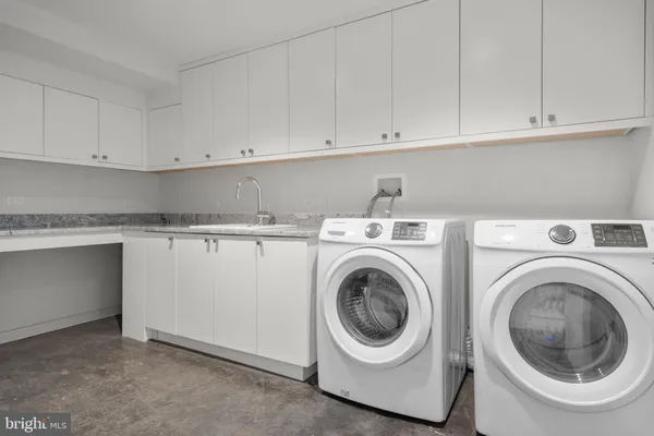 a utility room with sink dryer and washer