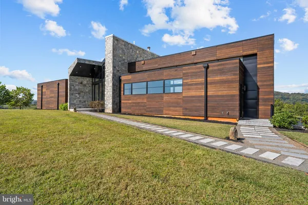 a view of an house with backyard and a tree