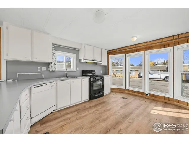 a kitchen with granite countertop a stove a sink and a refrigerator