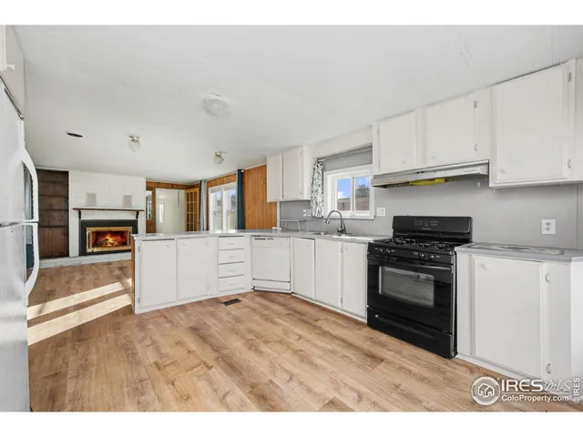 a kitchen with granite countertop a stove top oven and cabinets