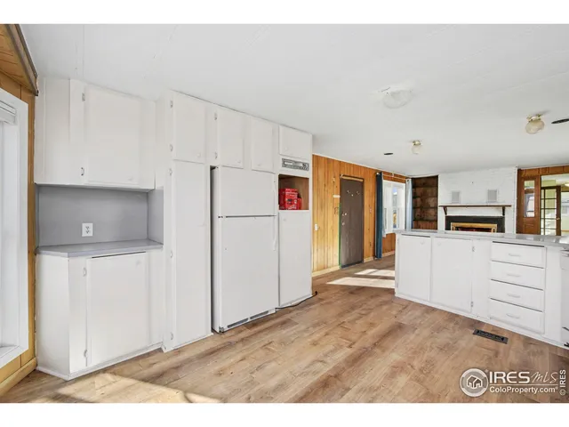 a kitchen with refrigerator cabinets and wooden floor