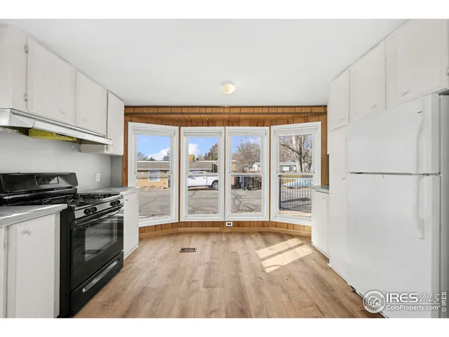 a open kitchen with granite countertop a stove top oven a sink and a refrigerator