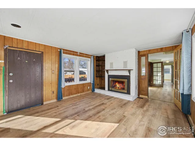 a view of an empty room with a window and fireplace