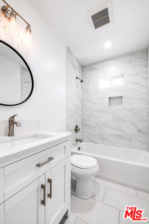 7422 Milwood Avenue Canoga Park, CA 91303 - Photo 12 of 15 a bathroom with a sink a toilet and a mirror