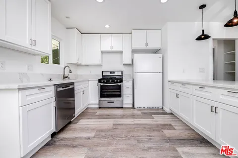 a kitchen with cabinets appliances and a window