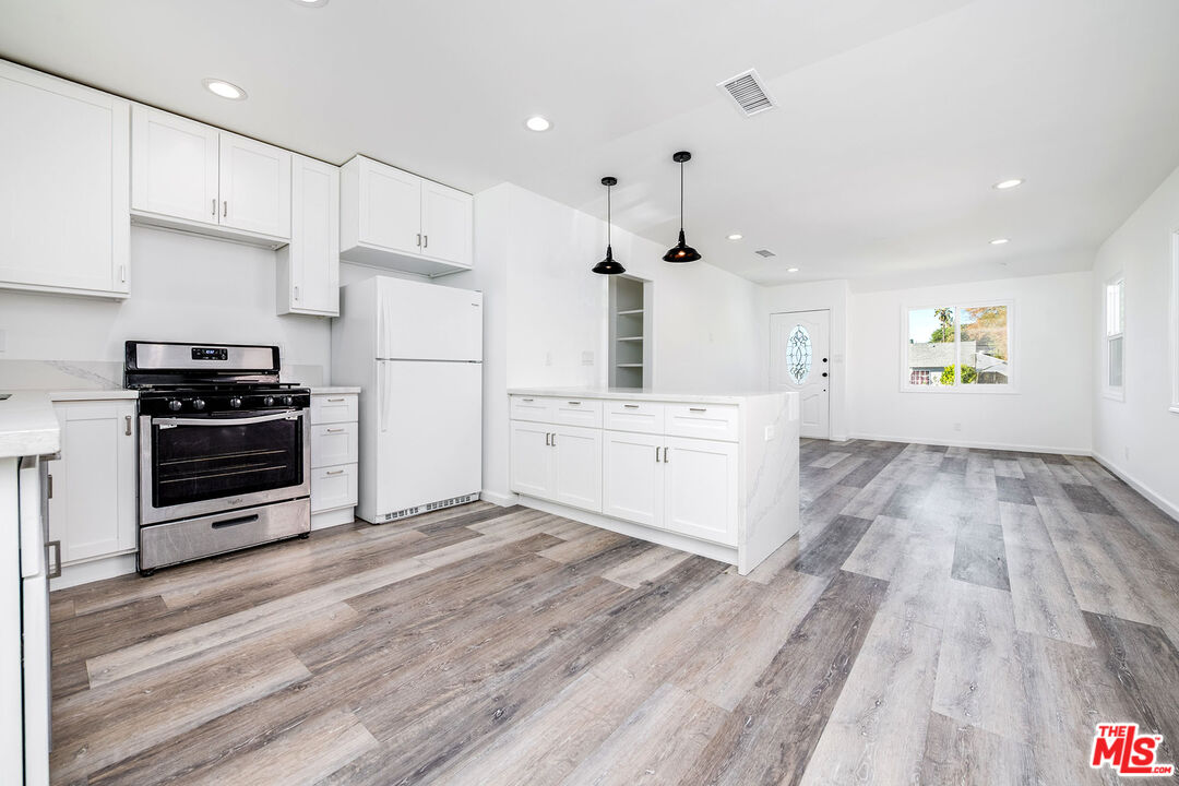 7422 Milwood Avenue Canoga Park, CA 91303 - Photo 7 of 15 a kitchen with stainless steel appliances a stove a refrigerator and a sink