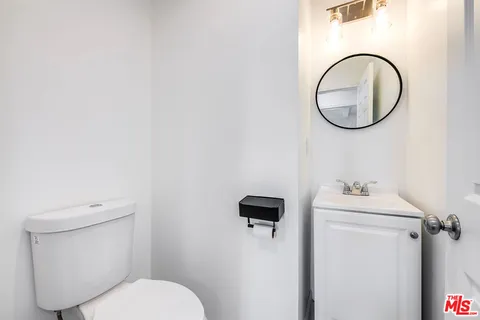a bathroom with a sink mirror and toilet
