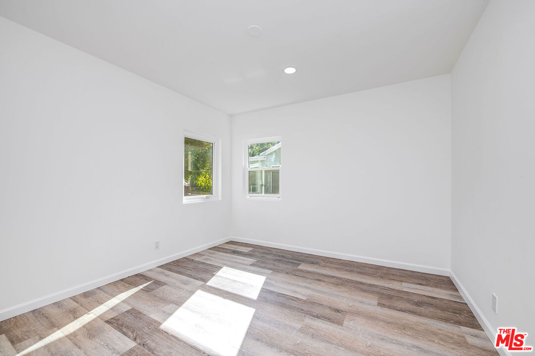 7422 Milwood Avenue Canoga Park, CA 91303 - Photo 10 of 15 an empty room with wooden floor and windows