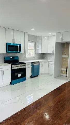 a kitchen with stainless steel appliances kitchen island granite countertop a stove a sink and a microwave