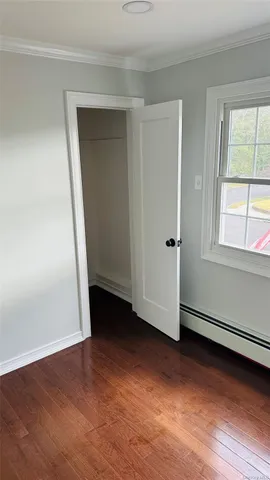 an empty room with wooden floor and white walls