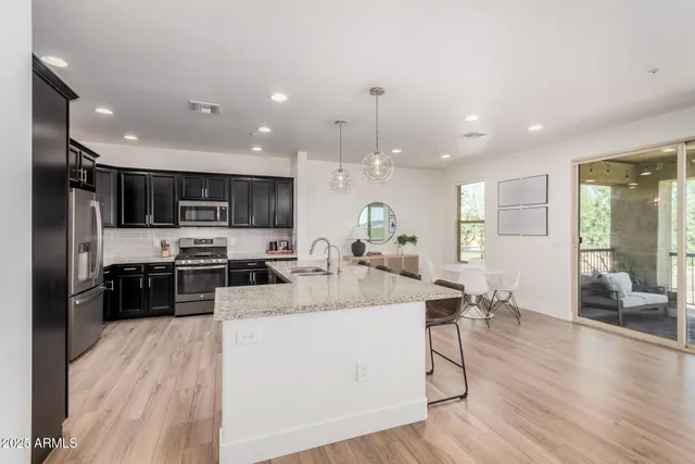a large kitchen with stainless steel appliances lots of counter space and wooden floor