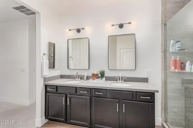 a bathroom with 2 sink and a mirror