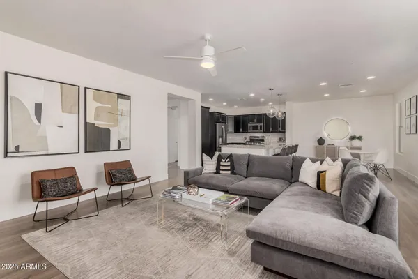 a living room with furniture and a view of kitchen