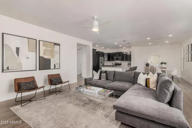 a living room with furniture and a view of kitchen
