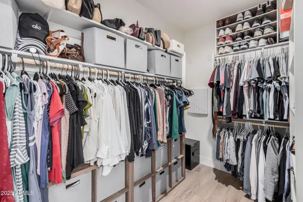 a view of walk in closet with clothes and shoes