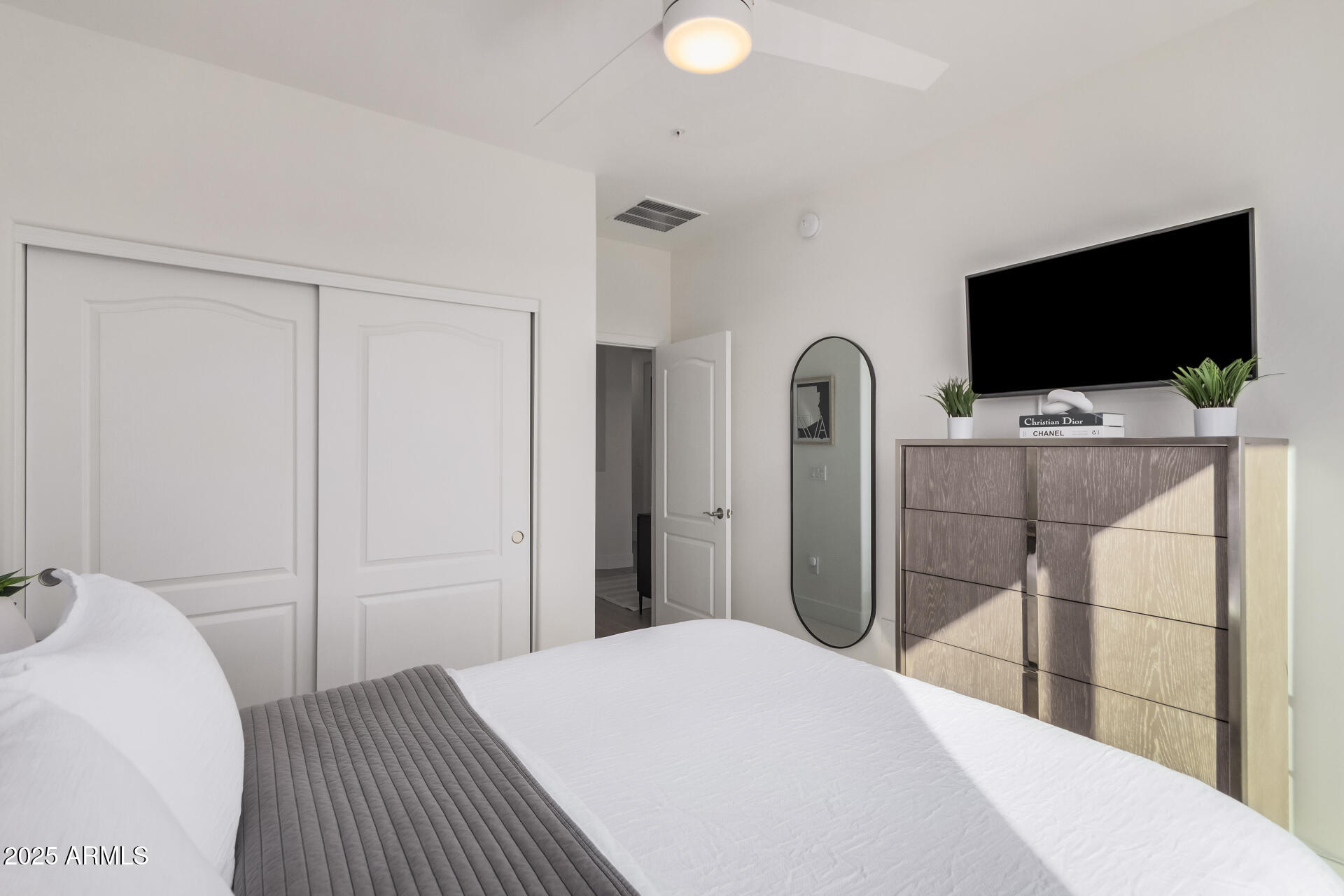 2425 West Bronco Butte Trail, Unit 2010 Phoenix, AZ 85085 - Photo 24 of 44 a bedroom with a bed and a flat screen tv