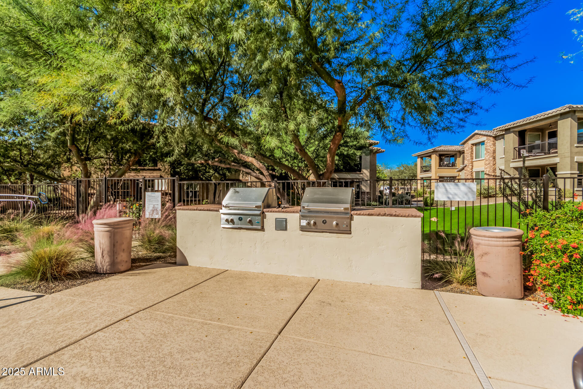 2425 West Bronco Butte Trail, Unit 2010 Phoenix, AZ 85085 - Photo 36 of 44 a view of a patio with table and chairs potted plants and large tree