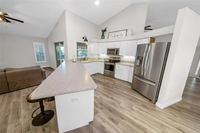 a kitchen with refrigerator cabinets and wooden floor