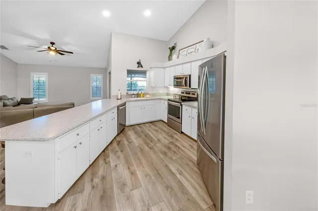 a large kitchen with a lot of counter space and wooden floor