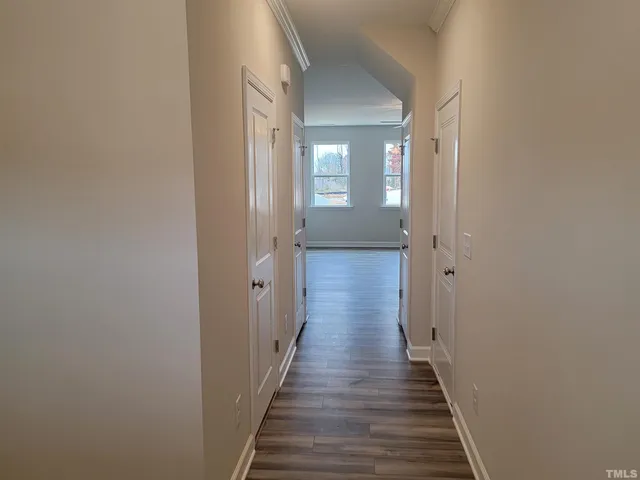 a kitchen with stainless steel appliances granite countertop a sink a stove a refrigerator and white cabinets