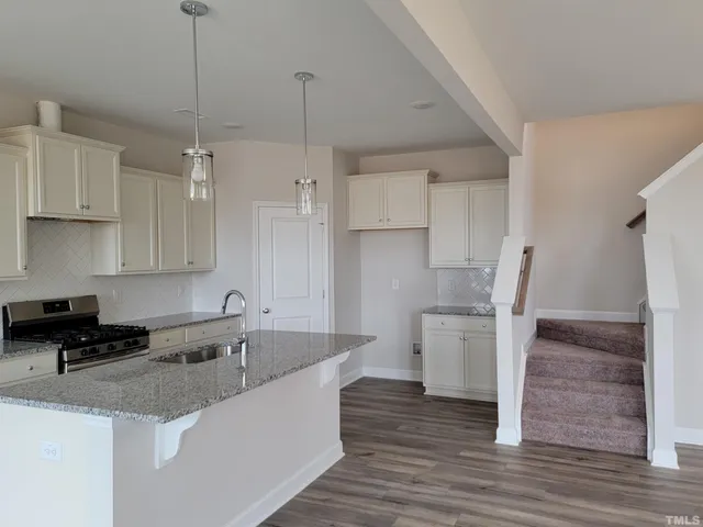 a kitchen with granite countertop wooden floors and stainless steel appliances