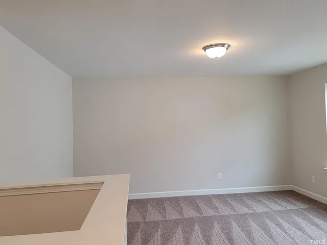 a living room with furniture and a view of kitchen