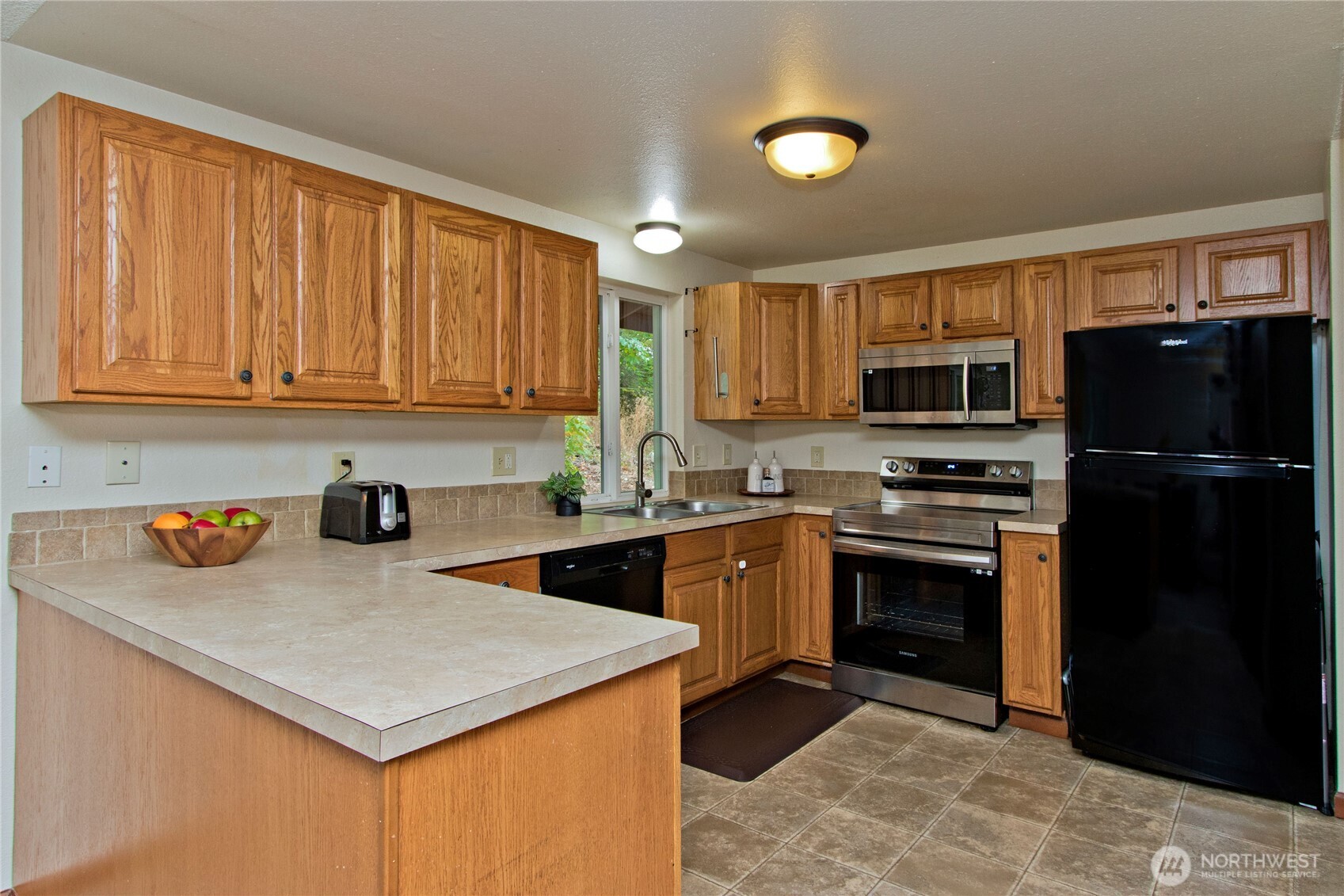 4237 South 326th Place Federal Way, WA 98001 - Photo 3 of 24 a kitchen with stainless steel appliances granite countertop a refrigerator stove top oven a sink and dishwasher