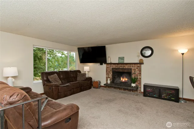 a living room with furniture a flat screen tv and a large window