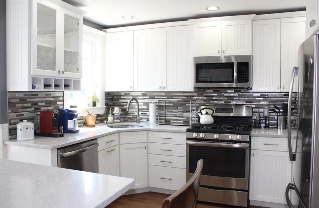 a kitchen with stainless steel appliances a stove sink microwave and cabinets