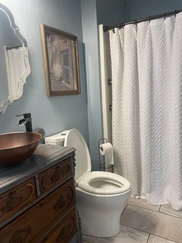 a bathroom with a toilet a sink and a mirror