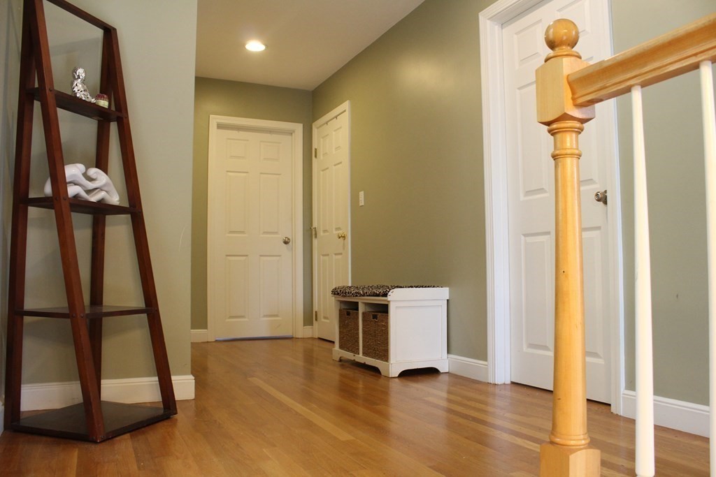 128 Colonial Road Marshfield, MA 02050 - Photo 12 of 21 a view of a hallway with wooden floor and door