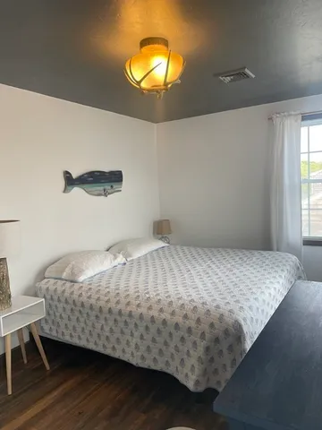 a bed sitting in a bedroom next to a window and a chandelier