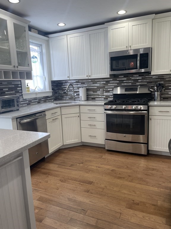 128 Colonial Road Marshfield, MA 02050 - Photo 2 of 21 a kitchen with stainless steel appliances granite countertop a stove a sink and a microwave