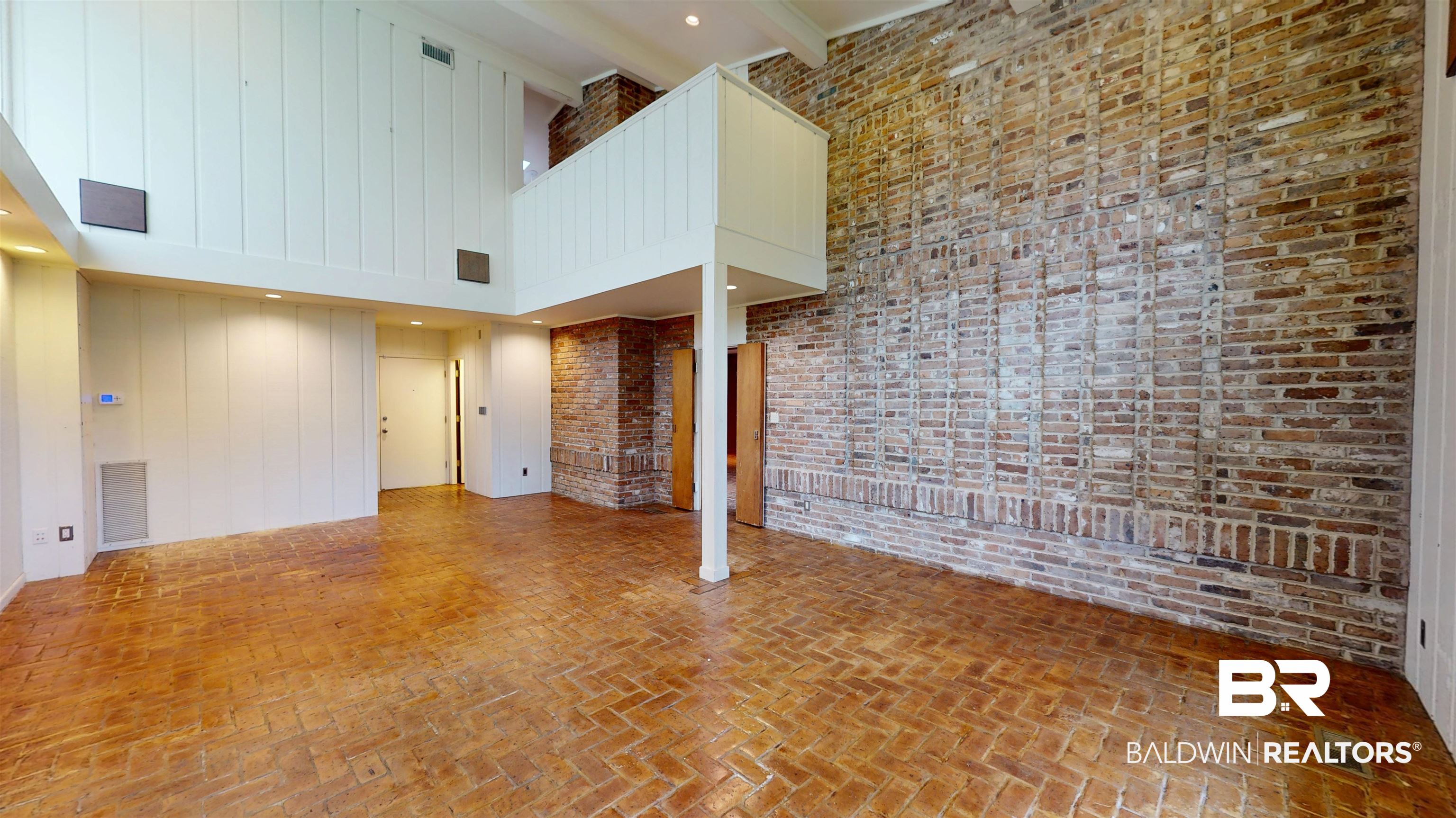 15 Spring Bank Road Mobile, AL 36608 - Photo 32 of 58 Unfurnished great room with a high ceiling, brick floors, recessed lighting, brick wall, and beamed ceiling
