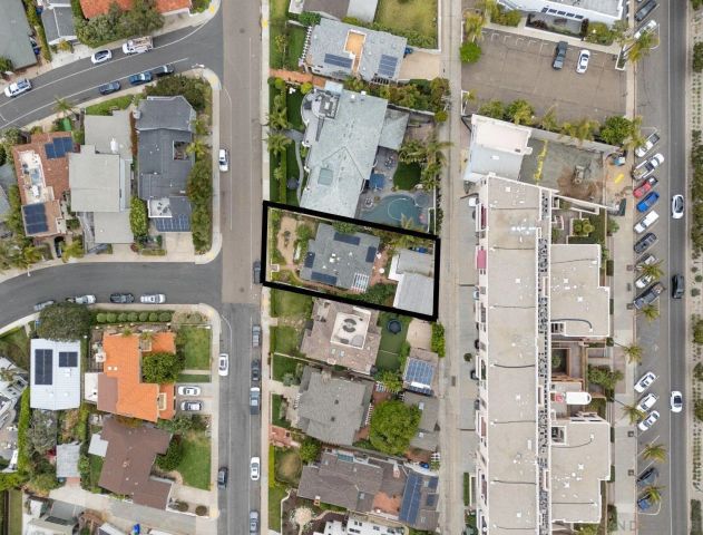 an aerial view of residential houses with outdoor space and street view