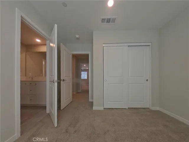 an empty room with closet and a bathroom
