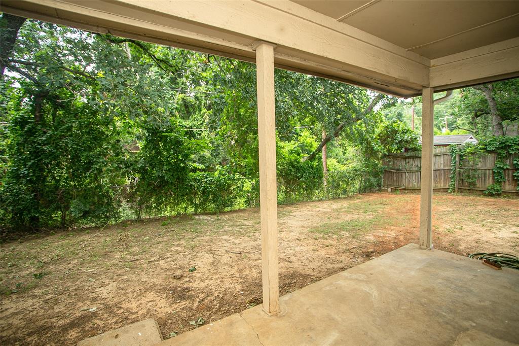 2019 West Nathan Lowe Road Arlington, TX 76017 - Photo 18 of 21 Concrete patio with a covered overhang, featuring a screen door and a single-pane window